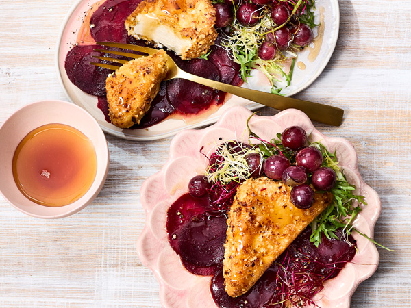 Cremiger Hirtenkäse in der Nusskruste mit Ahornsirup auf geschmorten Trauben und roter Bete